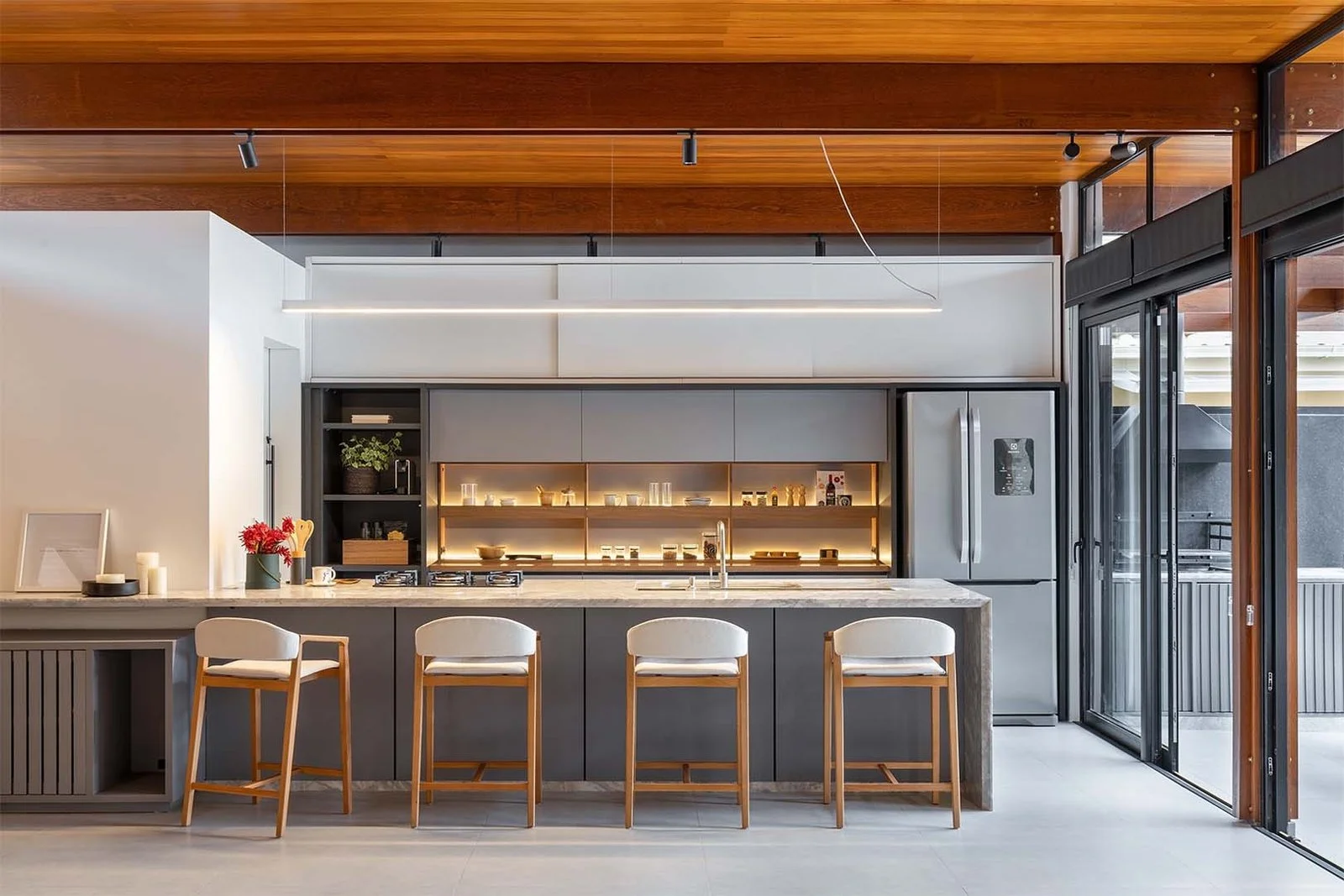 Cozinha com bancada e banquetas voltada para o jardim — Casa 88, VK Arquitetos