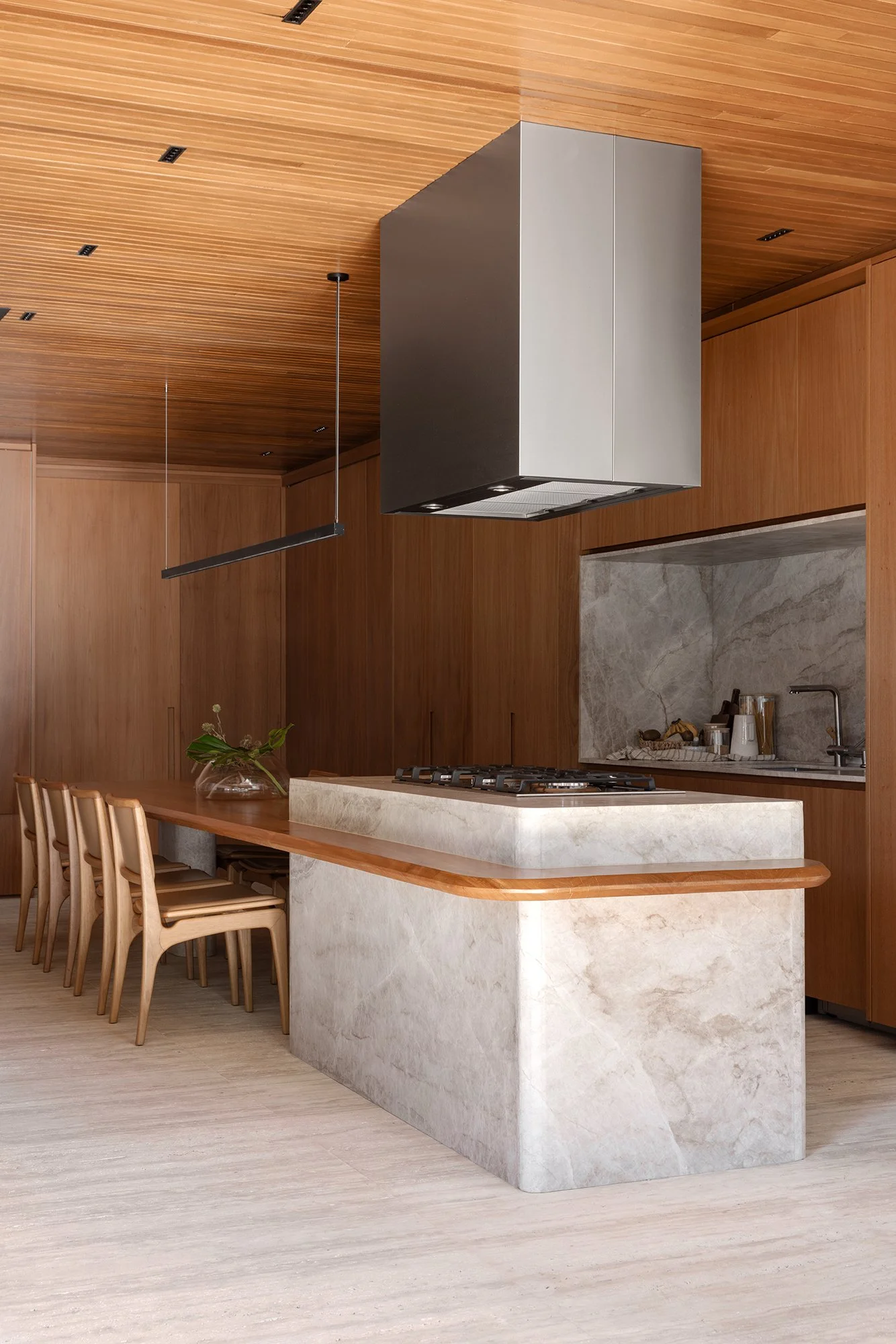 Ilha de cozinha em mármore sob coifa central — Apartamento Jequitibá, VK Arquitetos