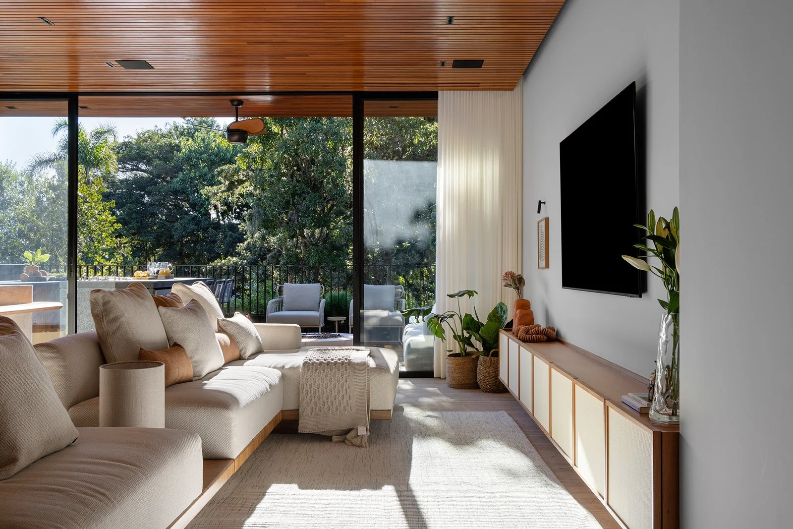 Estar com painel de TV e vista para o verde — Apartamento Jequitibá, VK Arquitetos