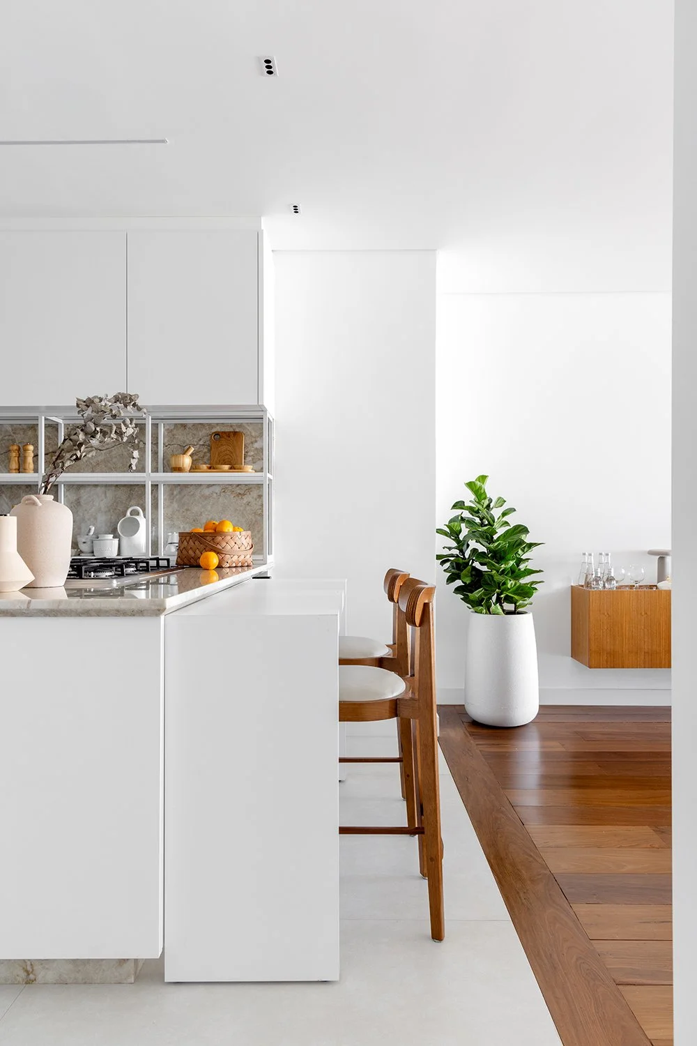 Cozinha com bancada branca e banquetas — Apartamento GM, VK Arquitetos