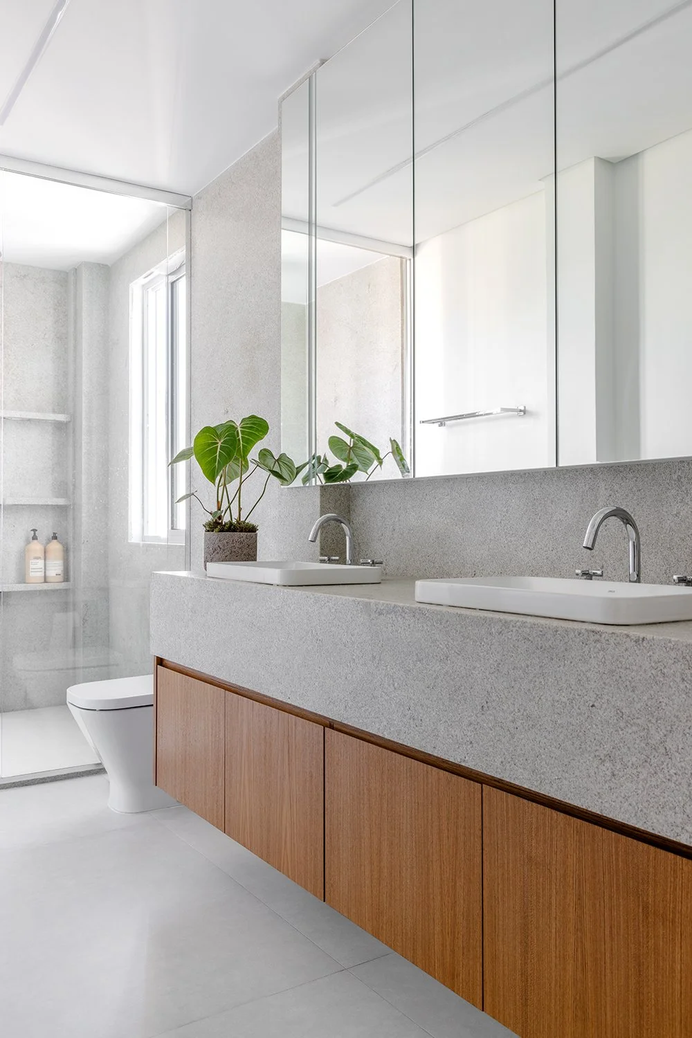 Banheiro com bancada de mármore e marcenaria amadeirada — Apartamento GM, VK Arquitetos
