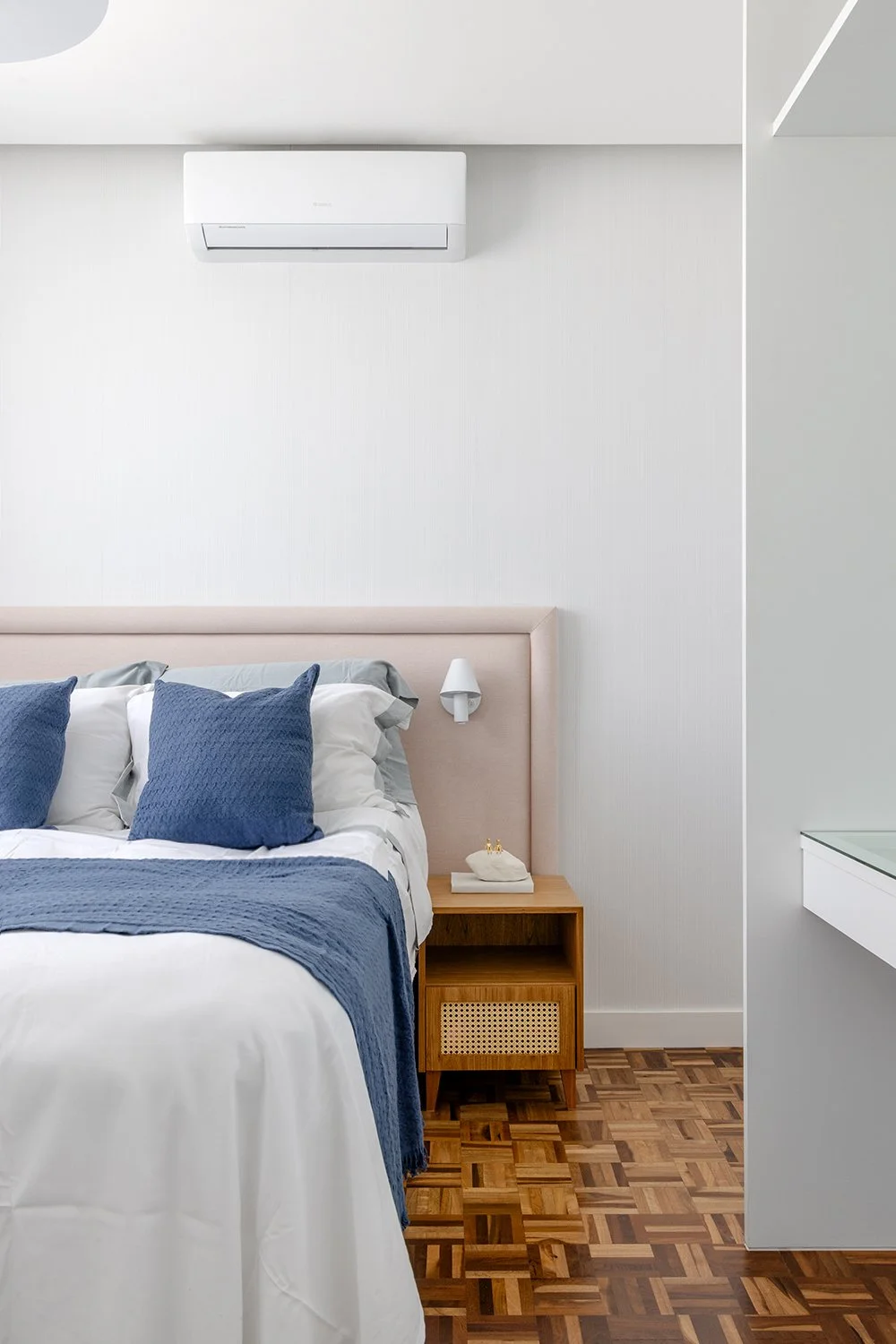 Suíte com roupa de cama azul e criado-mudo — Apartamento GM, VK Arquitetos