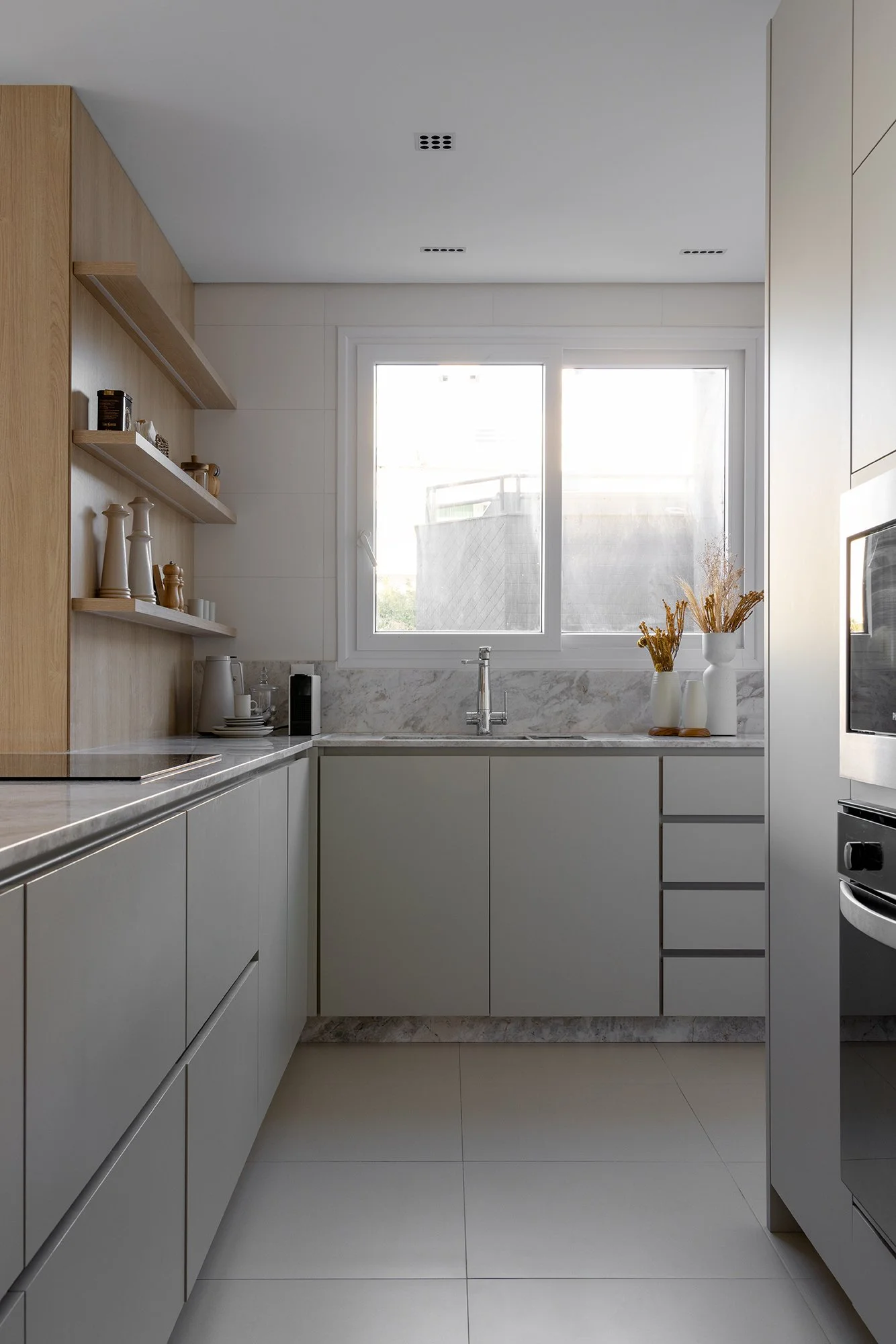 Cozinha com armários claros e bancada de mármore — Apartamento Brisa, VK Arquitetos