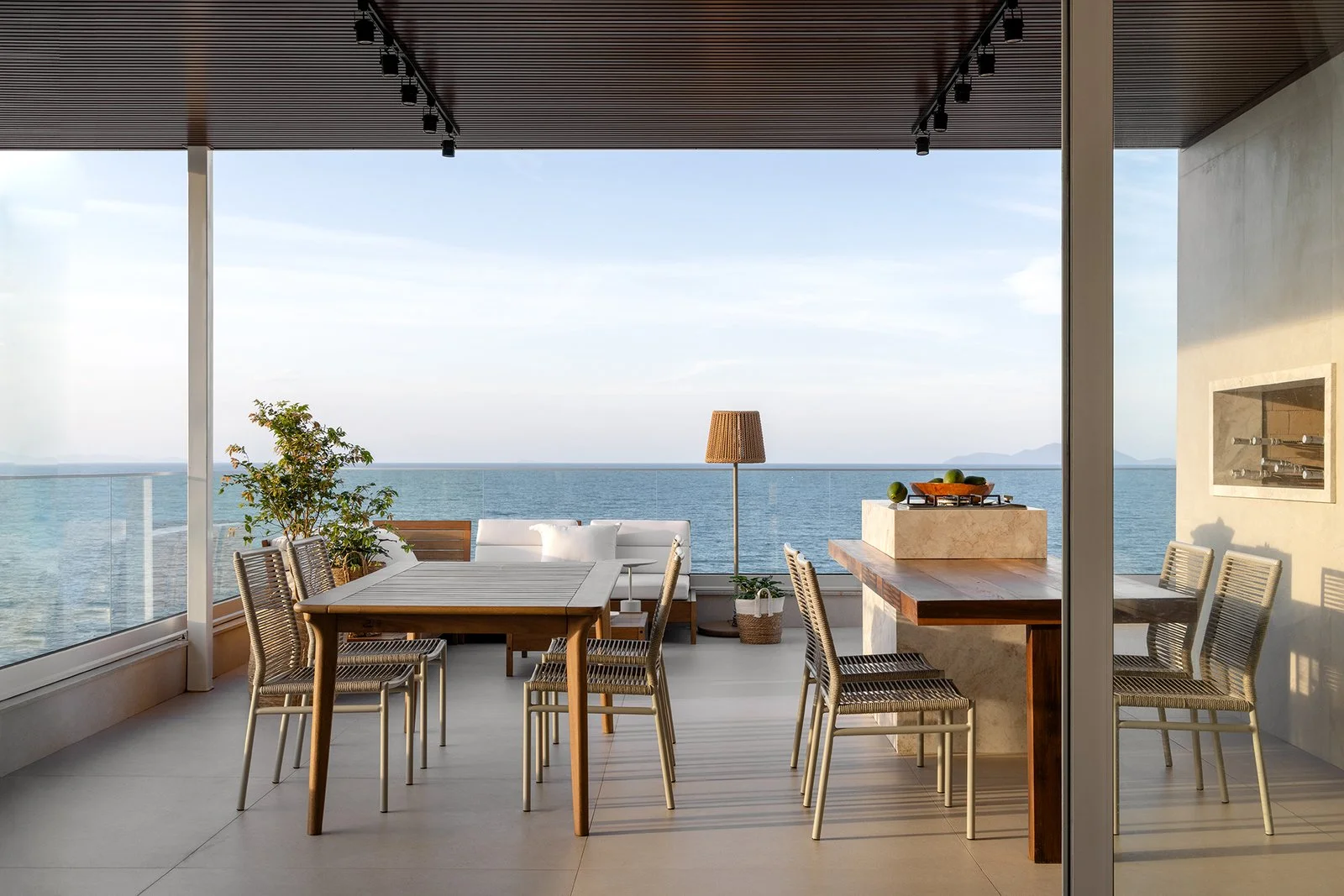 Varanda coberta com mesa e cadeiras de madeira — Cobertura Bleu, VK Arquitetos